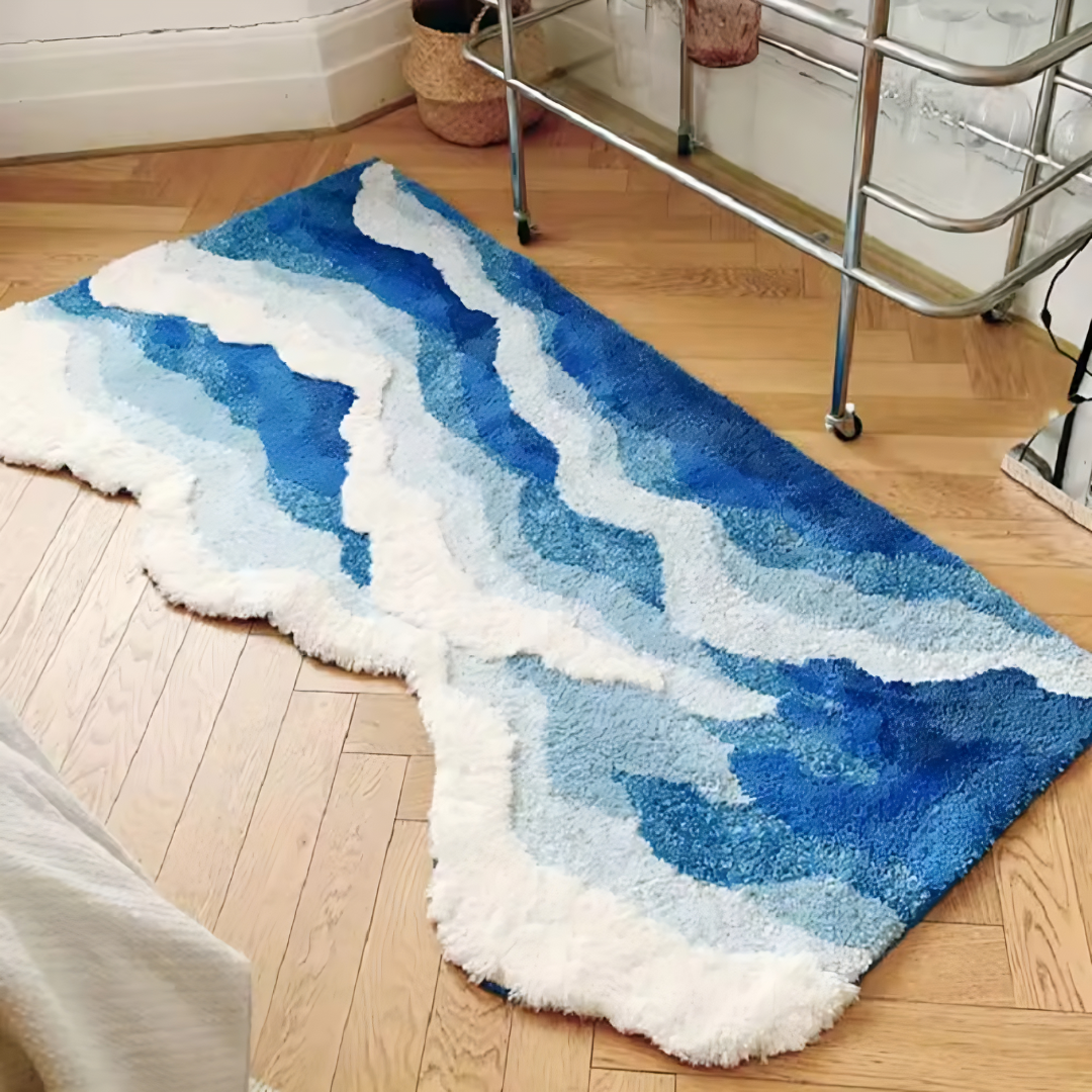 Alfombra Frutiger Aero colocada al pie de la cama, mostrando su diseño de olas con colores vivos y estilo Y2K sobre suelo claro.